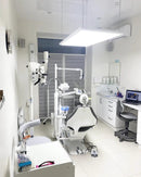 Dental clinic with dental chair, equipment, and computer. Shadowless hanging lamp by Pro Max Dental