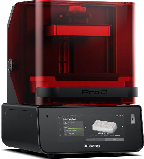 A red SprintRay Pro 2 3D printer designed for dental applications, showing the printer's window allowing light to pass through to the build platform.