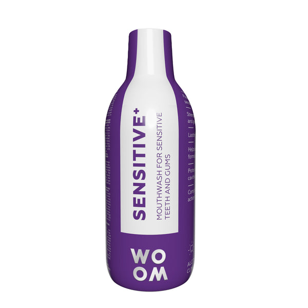 A bottle of mouthwash labeled 'SENSITIVE+' by WOOM, indicating it is formulated for sensitive teeth and gums.