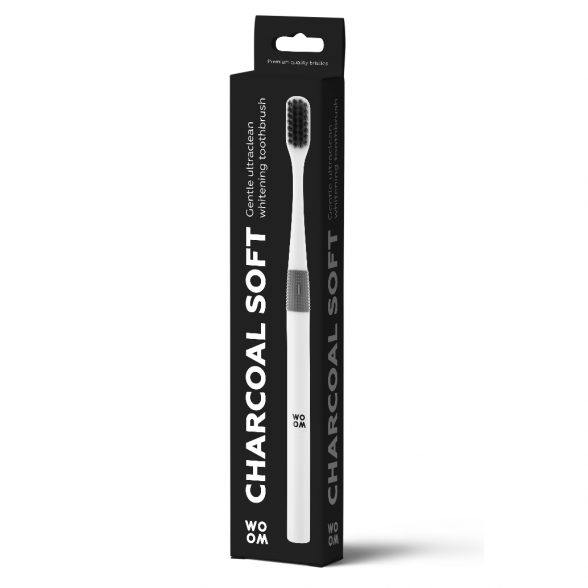Packaging of a charcoal soft toothbrush with white and gray colors showing the toothbrush with soft bristles and the package detailing features like ergonomically designed anti-slip handle and round brush head.
