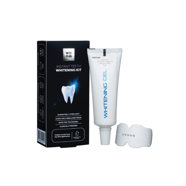 A teeth whitening kit by WOOM, including a tube of whitening gel and a silicone mouth tray, displayed alongside its packaging.