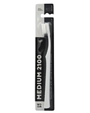 A black and white WOOM MEDIUM 2100 toothbrush in its packaging, displaying the toothbrush with white bristles and a ergonomic black handle.