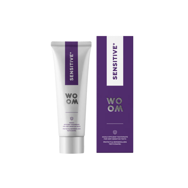 A tube of toothpaste labeled WOOM SENSITIVE+ next to its packaging box with a purple and white color scheme.