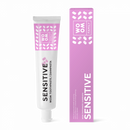 A tube of toothpaste labeled 'SENSITIVE' alongside its packaging box, both featuring a pink and white color scheme with leaf patterns.