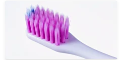 White toothbrush with pink bristles on a white background