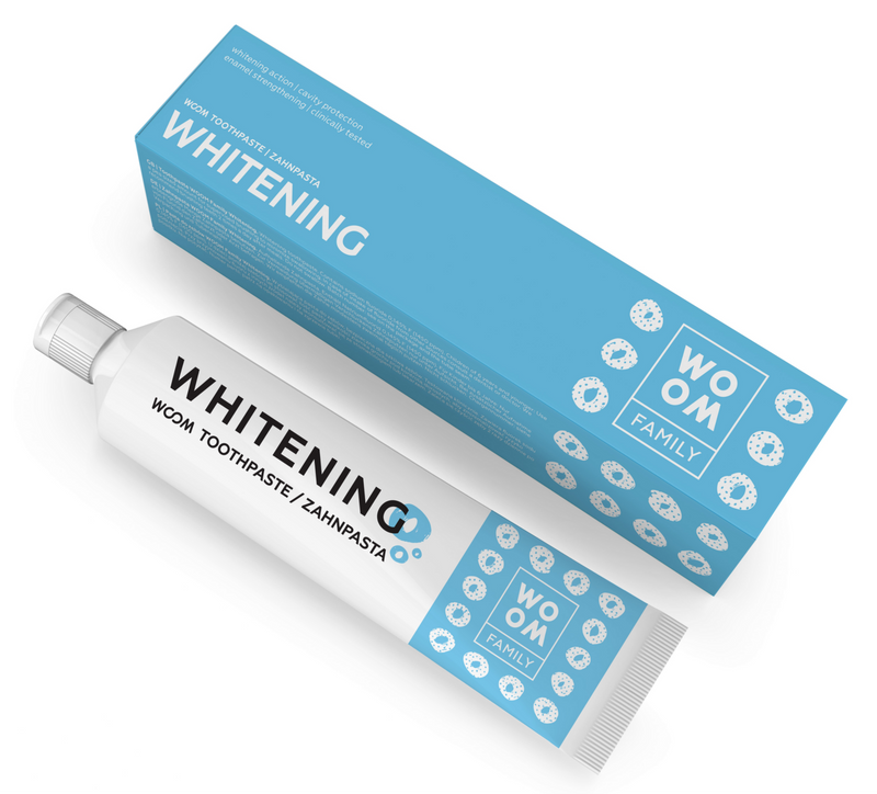 Packaging of WOOM Family Whitening Toothpaste, showing the tube and the box with 'WHITENING' written on them, indicating the product's function.